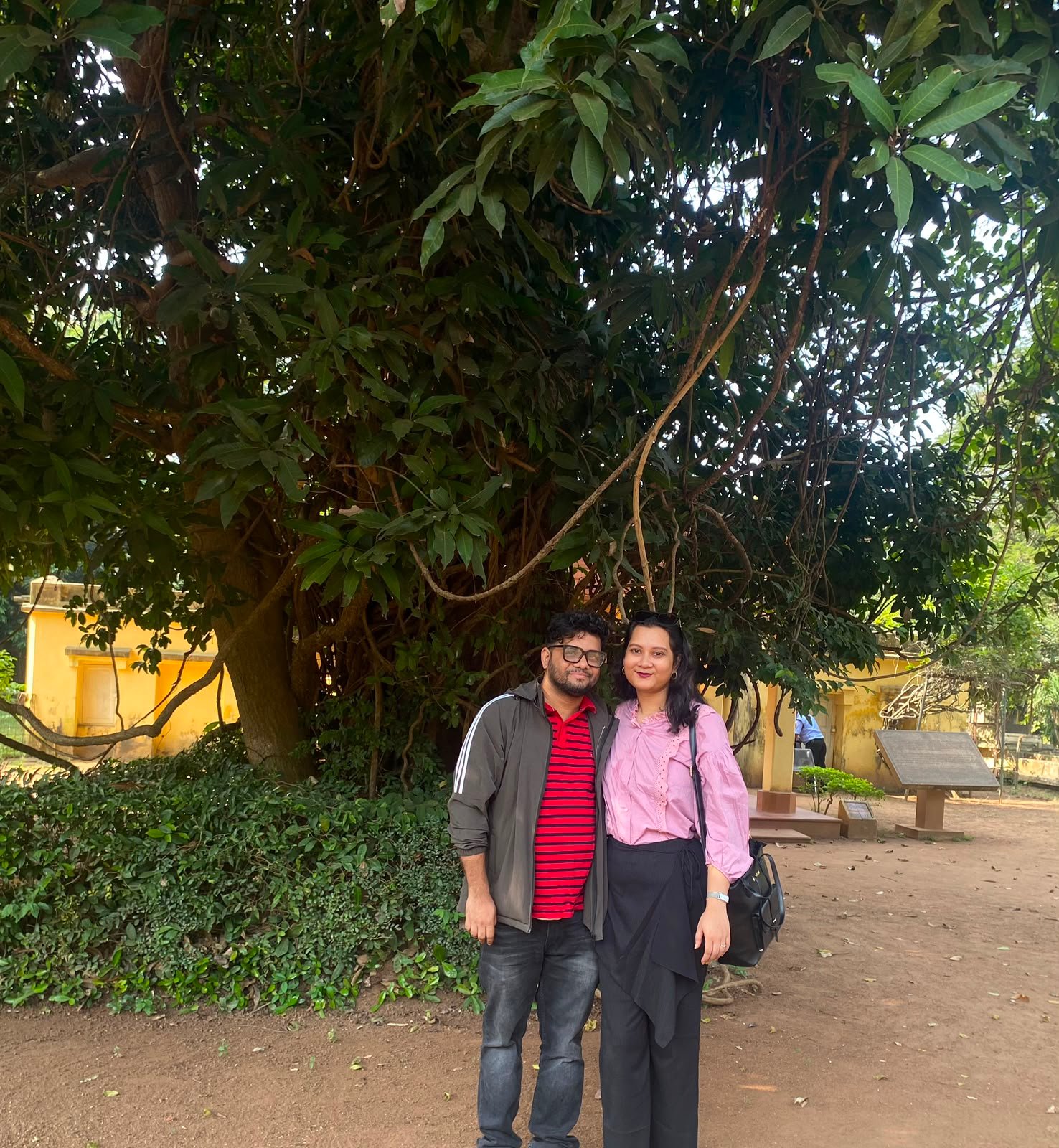 Zinia and Misbahul standing beneath a large tree